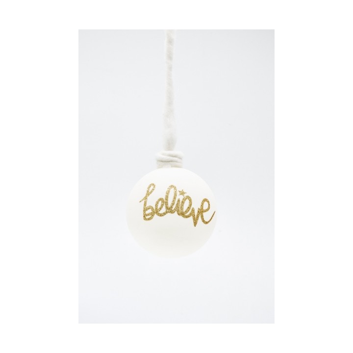 A white ornament with a gold glitter "believe" inscription, hanging from a simple twine.