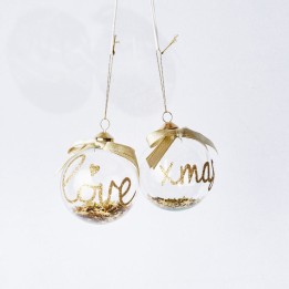 Balles en verre transparent avec inscriptions dorées, ornées de rubans, scintillantes.