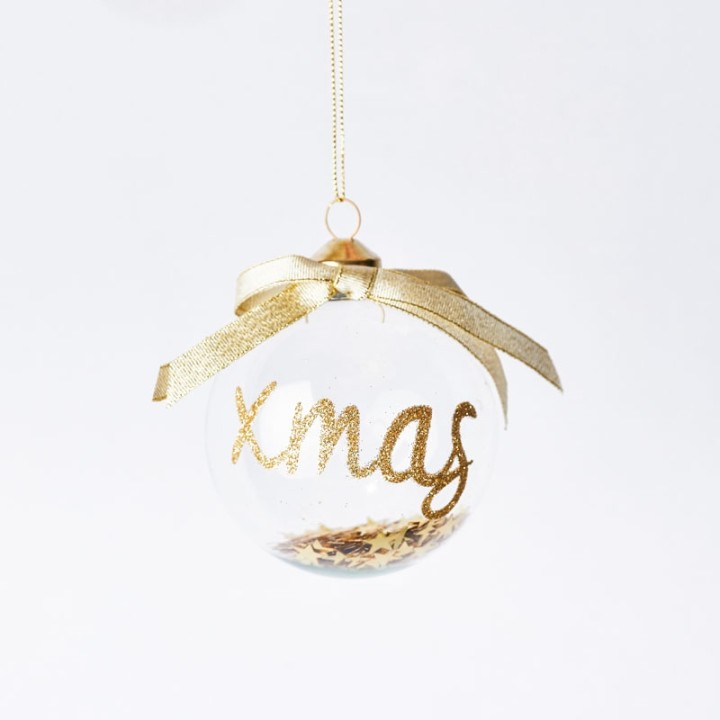Transparante kerstbal met gouden glitters en strik, elegant en feestelijk.