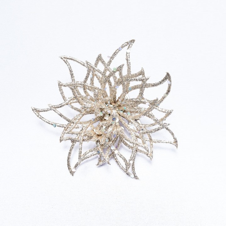 A delicate, shimmering silver flower brooch with intricate petal designs.
