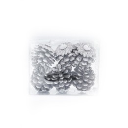 Pignes argentées ornées de fleurs blanches, présentées dans un écrin transparent.