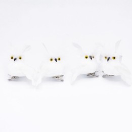Four small, white owl figurines with yellow eyes, perched on shiny silver clips.