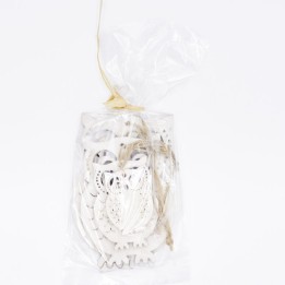 A transparent bag filled with intricately cut white wooden owl shapes.