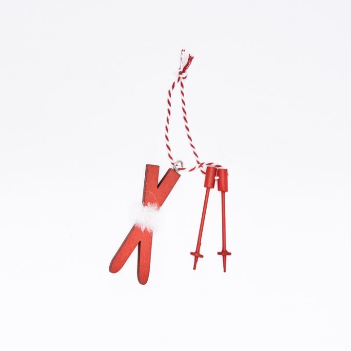 Red wooden ski ornament with white fur detail, hanging on a striped string.