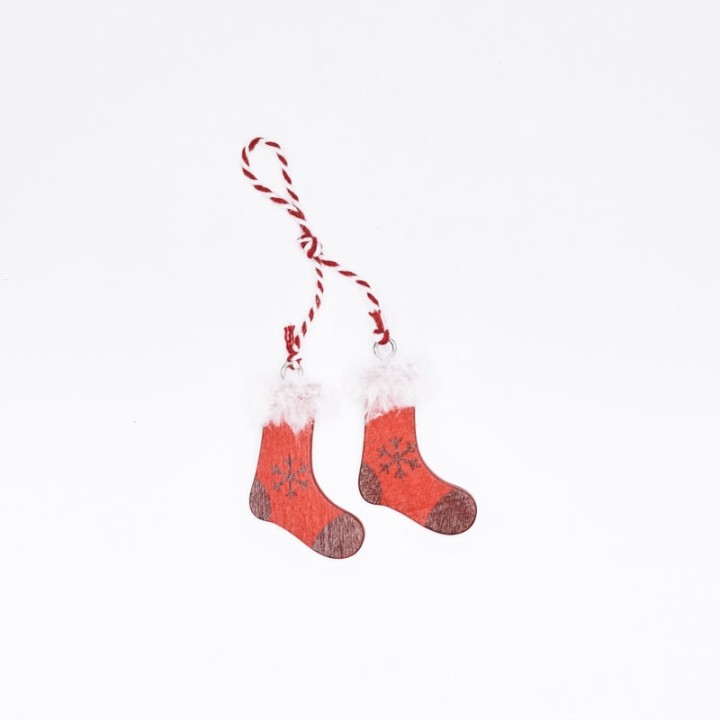 Two small red stockings with white fluffy tops, hanging from a red and white twisted string.
