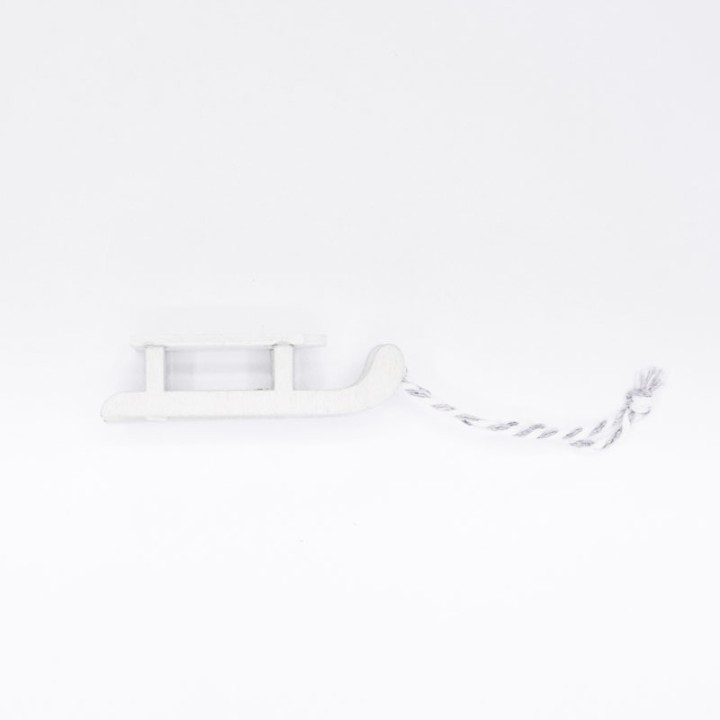 A simple white wooden sled with a twisted string for pulling.