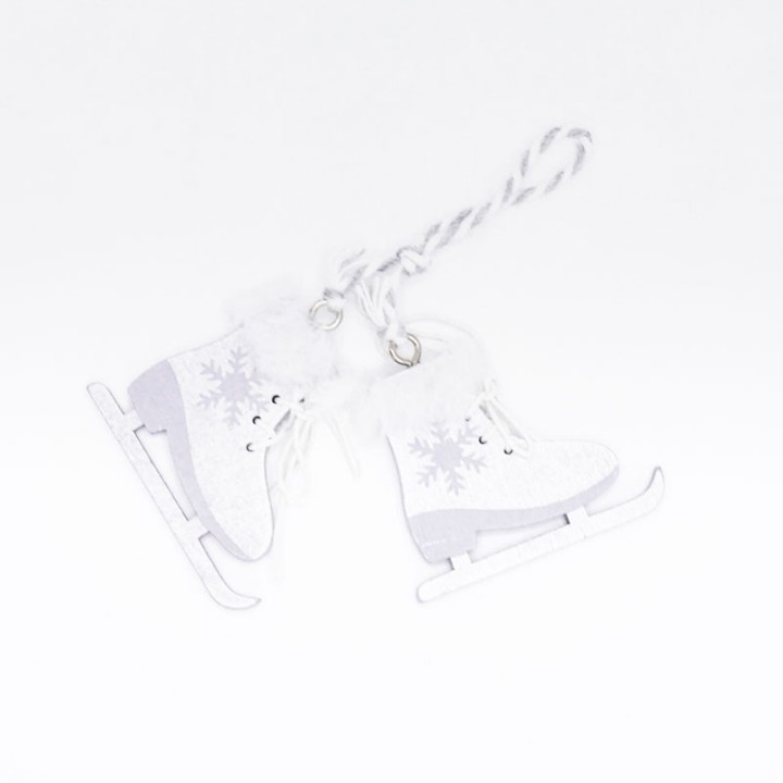 White ice skates with fluffy trim and snowflake designs, hanging from a twine loop.