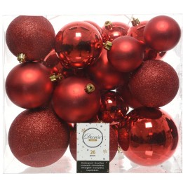 Een doos vol glanzende en matte rode kerstballen van verschillende groottes en texturen.