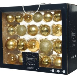 A box filled with shiny gold Christmas ornaments in various textures and sizes.