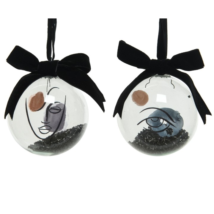Two glass ornaments with abstract face designs, featuring black and earthy tones and velvet bows.