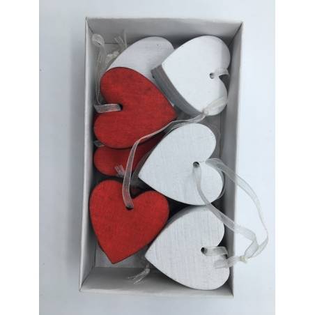 A box containing red and white wooden heart-shaped decorations with hanging ribbons.