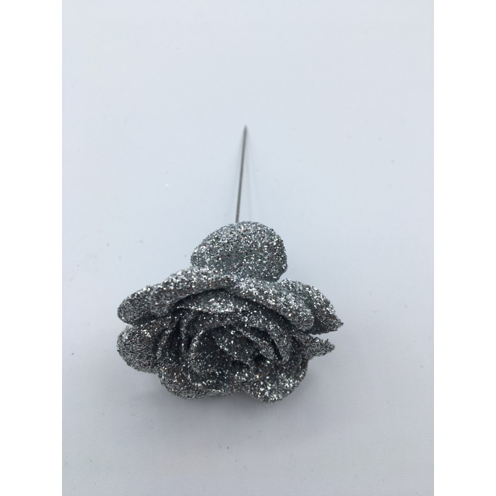 A sparkling silver rose made of glitter, resting on a thin metallic stem.
