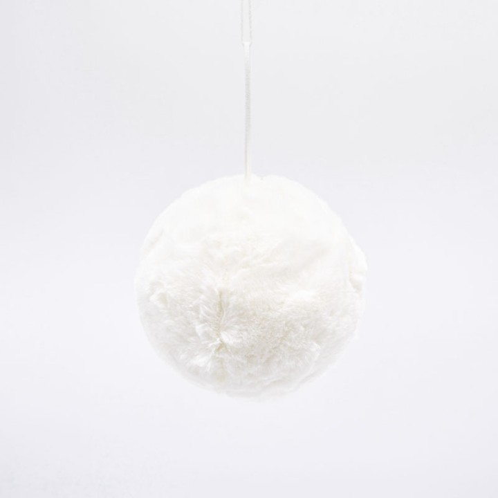A soft, round, white fluffy object suspended against a plain background.