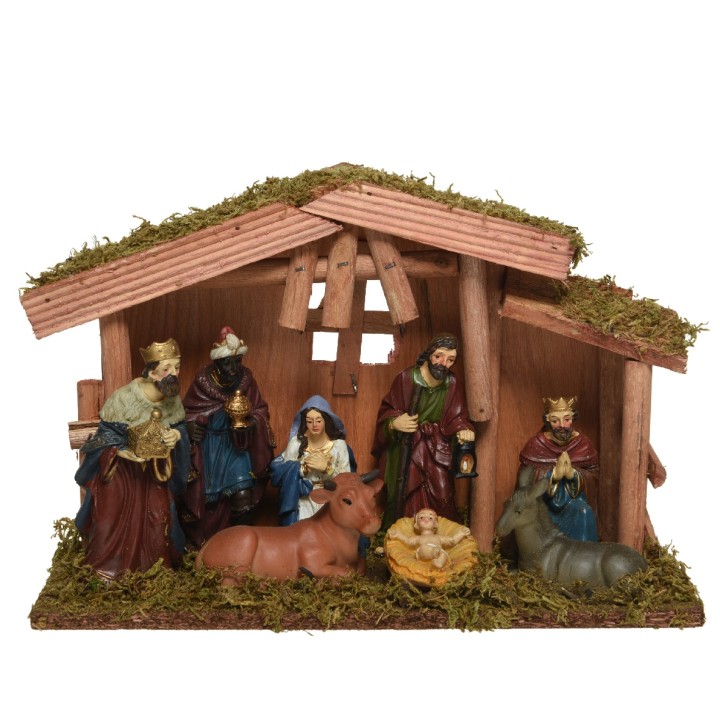 Crèche de Noël en bois, figurines colorées, mousse verte, ambiance chaleureuse et festive.