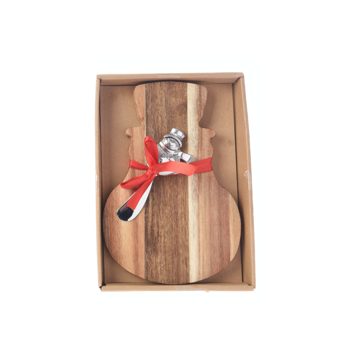 A wooden cutting board shaped like a snowman, adorned with a silver spoon and red ribbon.