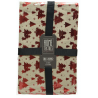 Nappe décorative beige ornée de sapins rouges, emballée avec un ruban noir.