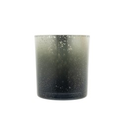 A cylindrical glass candle holder with a gradient from dark gray to clear, speckled surface.