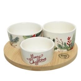 Drie keramische schalen met kerstmotieven op een ronde houten onderzetter.