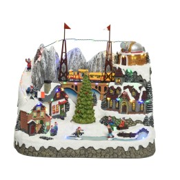 A snowy village scene with a bridge, Christmas tree, and colorful miniature buildings.