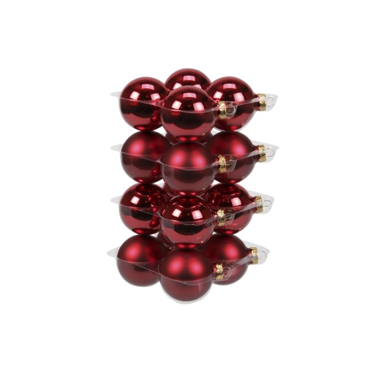 Shiny red Christmas ornaments stacked in clear plastic packaging.