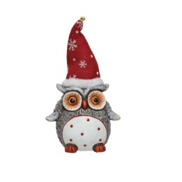 A festive owl figurine wearing a red snowflake-patterned hat, with big orange eyes.