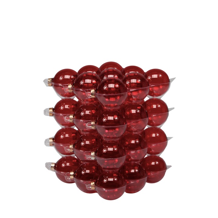 A stacked arrangement of shiny red glass ornaments in a pyramid formation.