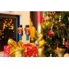 Twee houthakkers in feestelijke kleuren staan naast een kerstboom met glinsterende decoraties.