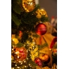 A close-up of a festive Christmas tree adorned with shiny red and gold ornaments.
