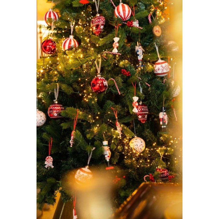 A festive Christmas tree adorned with red and white ornaments and twinkling lights.