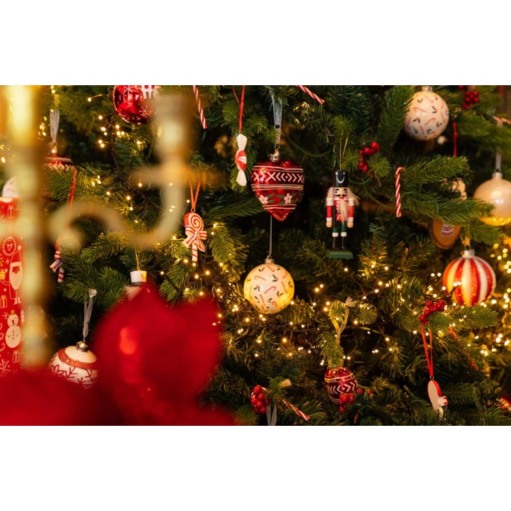 Ornements colorés et guirlandes lumineuses sur un sapin de Noël festif.