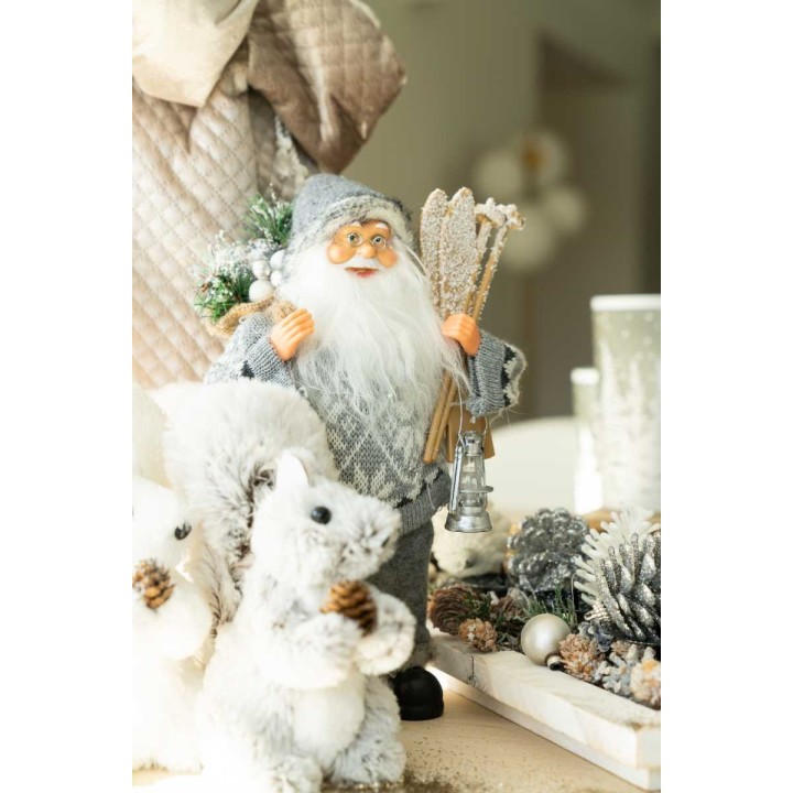 Een schattige kerstman met een grijze outfit, omringd door witte sneeuwdieren en dennenappels.