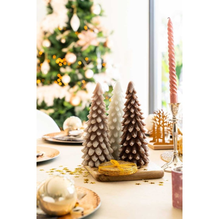 Pastel-hued cone-shaped decorations on a festive table with a glowing tree in the background.