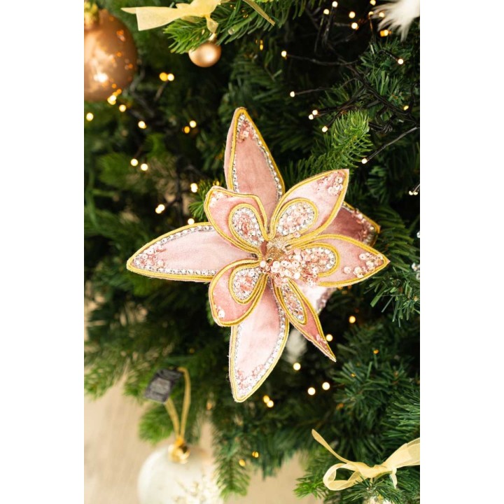 A delicate pink flower ornament with sparkling details adorning a lush green Christmas tree.