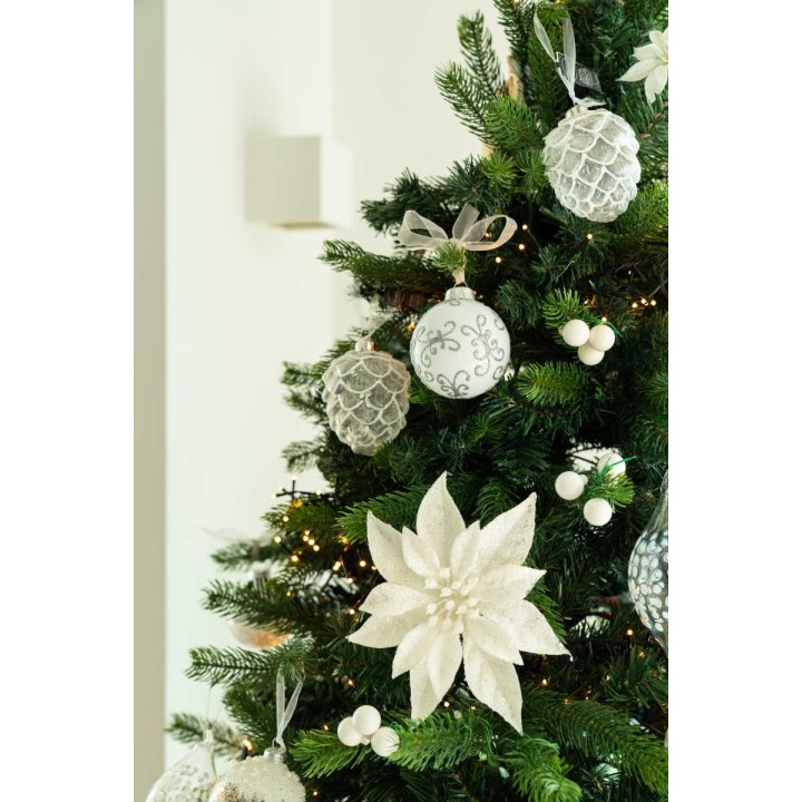 A beautifully decorated Christmas tree with silver and white ornaments and a large white flower.