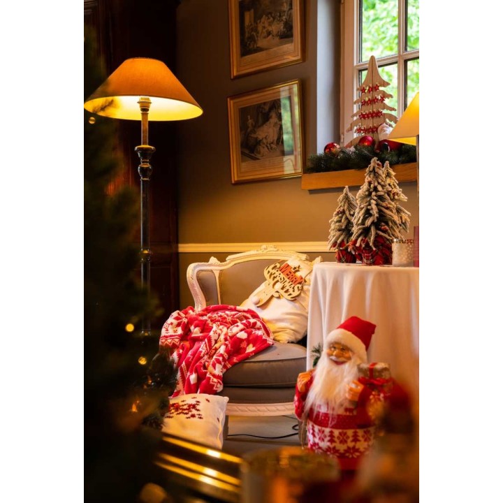 Cozy holiday scene with warm lighting, festive decor, and a cheerful Santa figure.