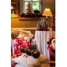 Ambiance chaleureuse de Noël avec décorations luxuriantes et couleurs festives.
