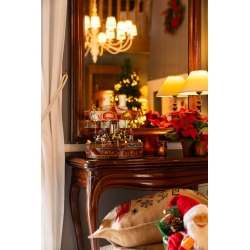 Kerstachtige scène met een houten tafel, een spiegel, lichtjes en een draaiorgel.