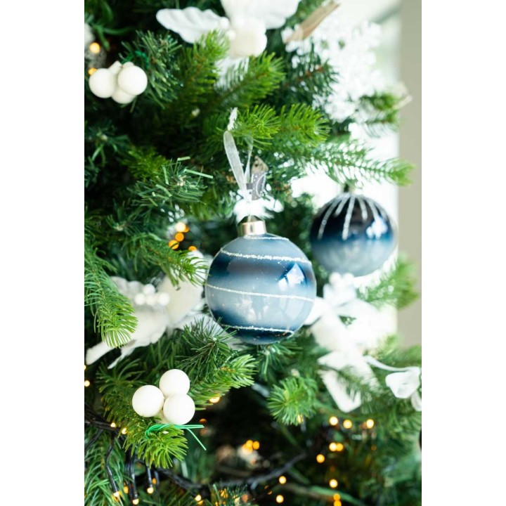 A decorated evergreen tree with blue and white ornaments, white berries, and twinkling lights.