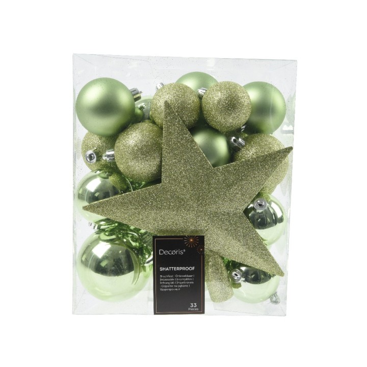 Groene kerstversiering in een doorzichtige verpakking, met glanzende ballen en een grote ster.