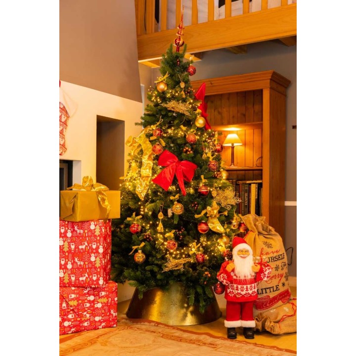 Sapin décoré de rouge et or, entouré de cadeaux et d'un père Noël en peluche.