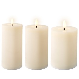 Three tall, white candles with gentle flames flickering on top.