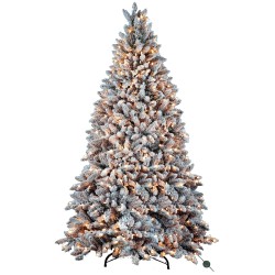 A frosted artificial Christmas tree, lush and layered, adorned with warm glowing lights.