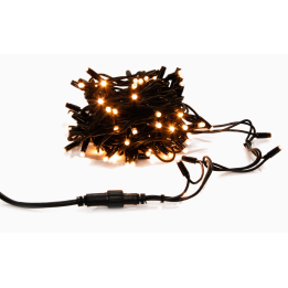 A tangled bundle of warm white fairy lights on dark wire, glowing softly.