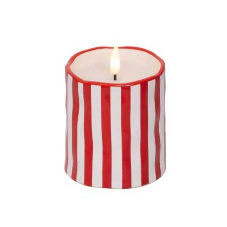 Bougie ronde aux rayures rouges et blanches, flamme vacillante au centre.
