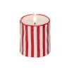 Bougie ronde aux rayures rouges et blanches, flamme vacillante au centre.