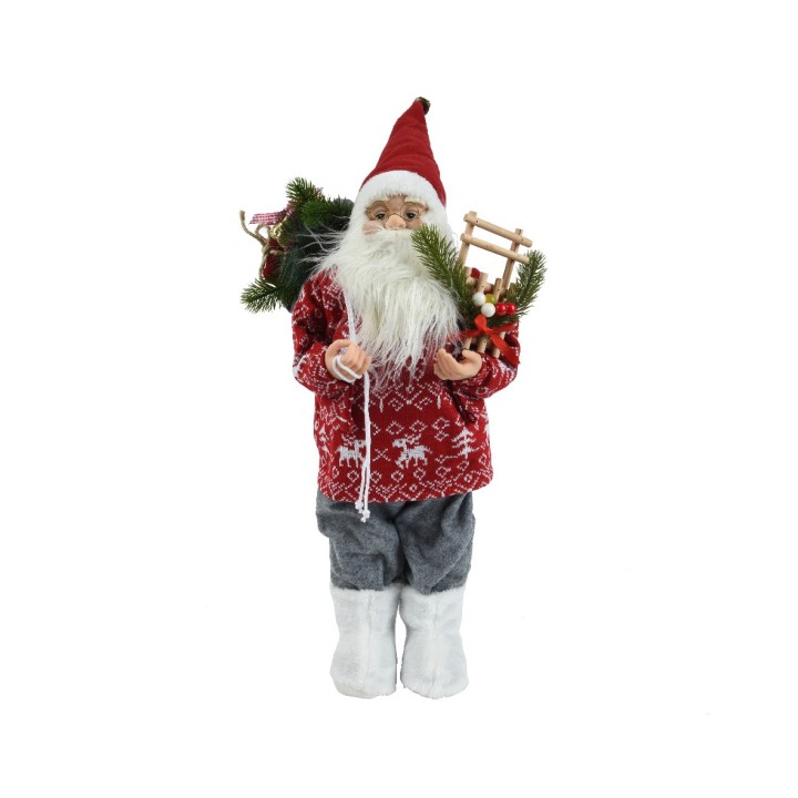 Poupée de Noël avec pull rouge, traîneau miniature et décorations végétales.
