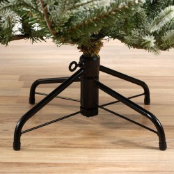 Support noir en métal pour arbre de Noël, sur un sol en bois clair.