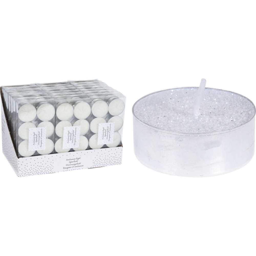 Zeshoekige witte theelichten in een glanzende doos naast een grote, transparante kaars met glitters.