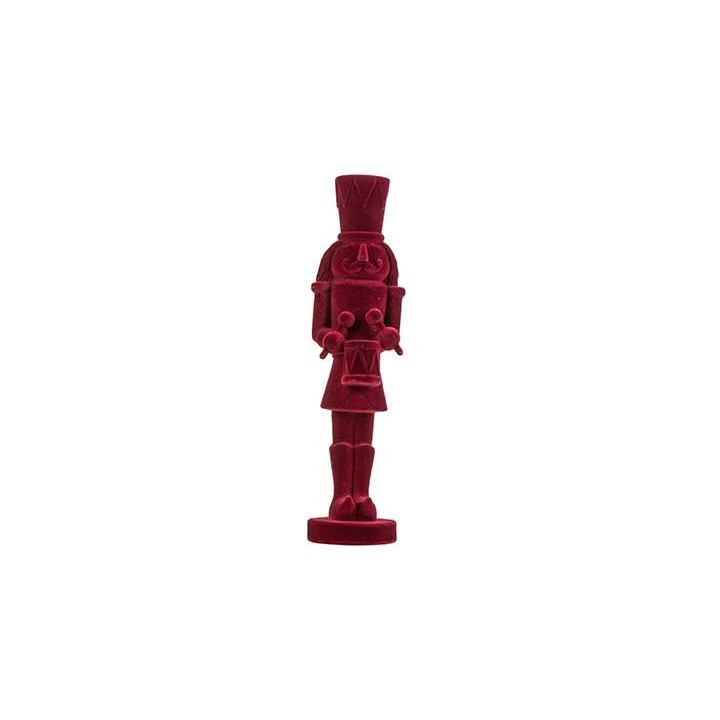 A vibrant red nutcracker figure with a tall hat and expressive face, standing on a circular base.