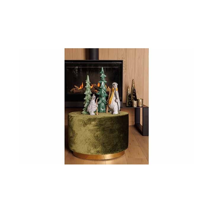 A cozy scene with green ceramic trees and animal figurines atop a plush, round, gold-accented stool.